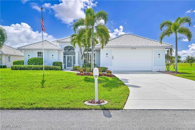 mediterranean / spanish-style house featuring a garage and a front yard