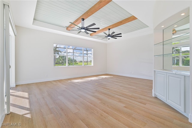 unfurnished living room featuring light hardwood / wood-style floors, beamed ceiling, wooden ceiling, and ceiling fan