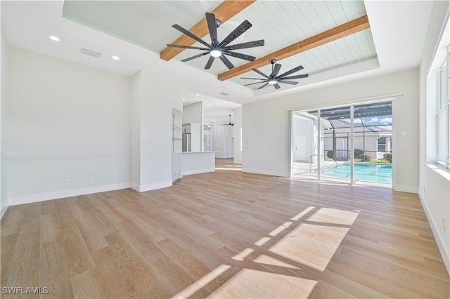 unfurnished living room featuring ceiling fan, beamed ceiling, light hardwood / wood-style floors, and wooden ceiling