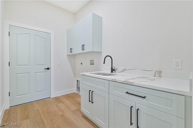 clothes washing area with cabinets, light hardwood / wood-style floors, sink, electric dryer hookup, and hookup for a washing machine