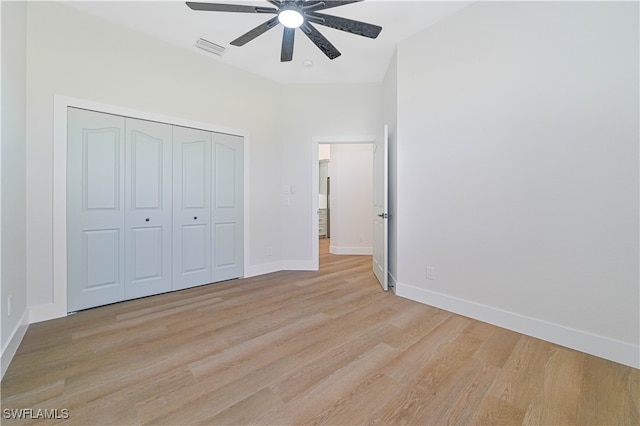 unfurnished bedroom featuring light wood-type flooring, ceiling fan, and a closet