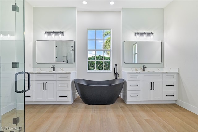 bathroom featuring wood-type flooring, vanity, and separate shower and tub