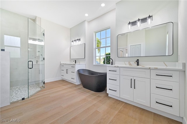 bathroom featuring vanity, separate shower and tub, and hardwood / wood-style floors