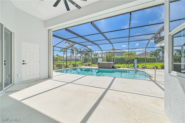 view of pool with ceiling fan, glass enclosure, and a patio