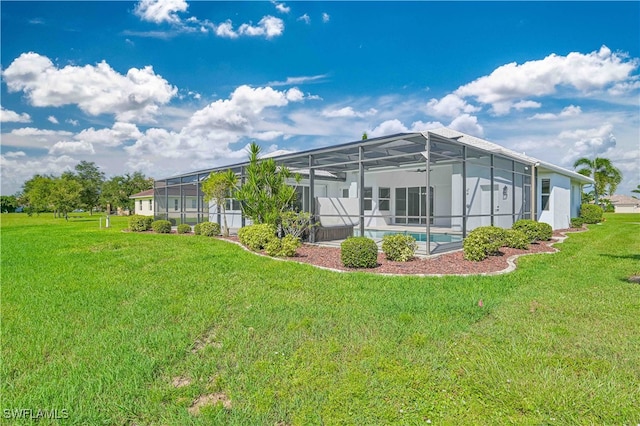 rear view of house with glass enclosure, a yard, and a swimming pool