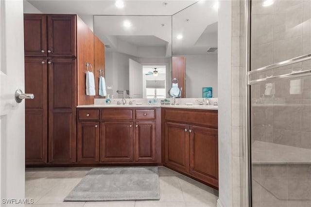 bathroom with tile patterned floors, vanity, and a shower with door