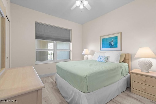 bedroom featuring ceiling fan, a closet, and light hardwood / wood-style flooring