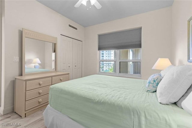 bedroom featuring ceiling fan, light wood-type flooring, and a closet