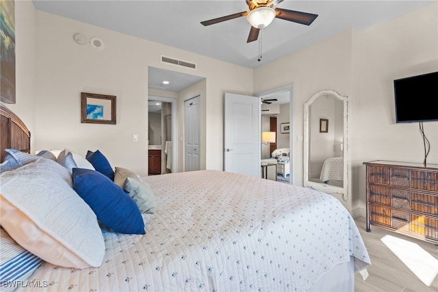 bedroom featuring connected bathroom, ceiling fan, a closet, and light wood-type flooring