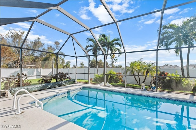 view of pool with glass enclosure and a patio