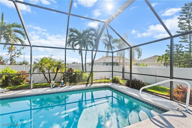 view of swimming pool featuring a lanai