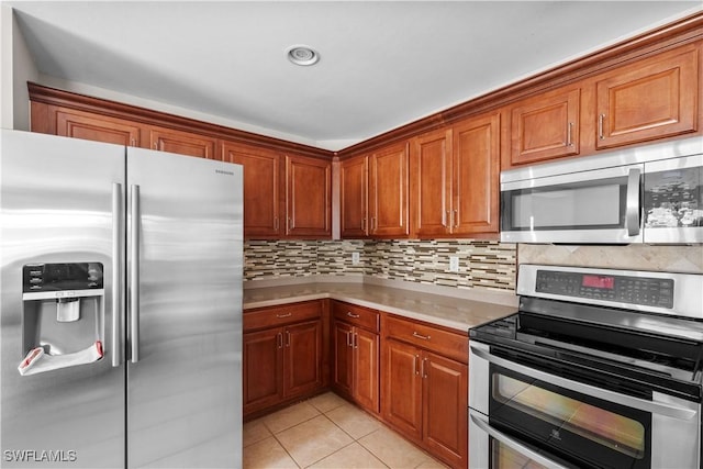 kitchen featuring backsplash, stainless steel appliances, and light tile patterned floors