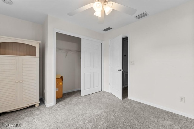 unfurnished bedroom with ceiling fan, light colored carpet, and a closet