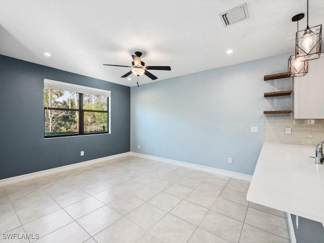 tiled spare room with ceiling fan