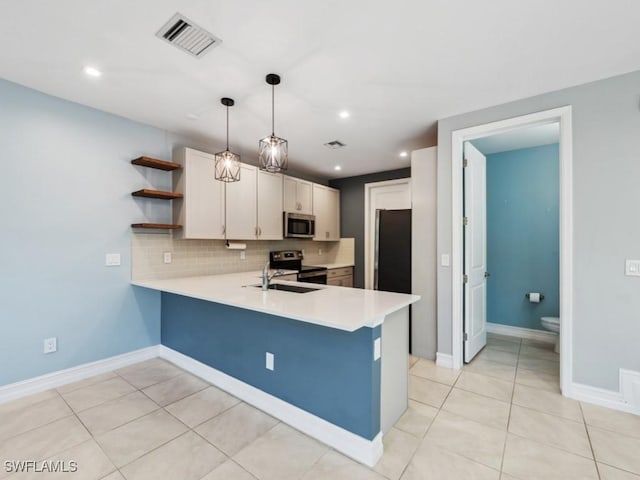 kitchen with appliances with stainless steel finishes, pendant lighting, white cabinets, and kitchen peninsula