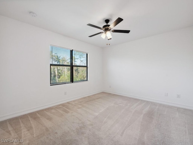 spare room with ceiling fan and light carpet