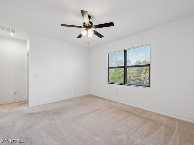 spare room featuring light carpet and ceiling fan