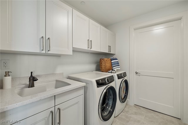 clothes washing area with cabinet space, washer and clothes dryer, and a sink