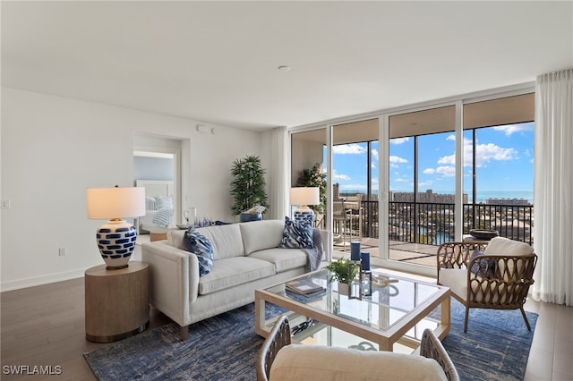 living area featuring baseboards, a wall of windows, and wood finished floors