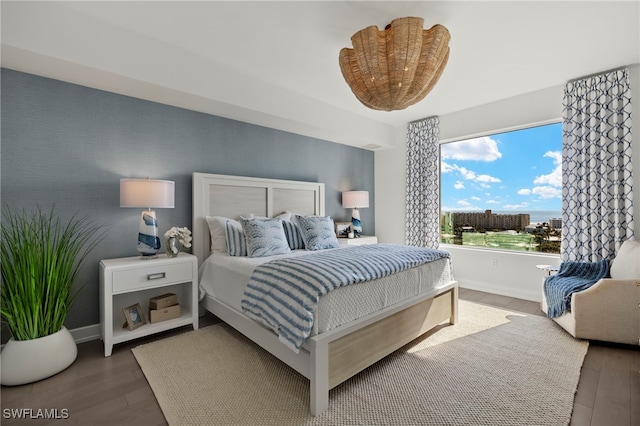 bedroom with wood finished floors and baseboards