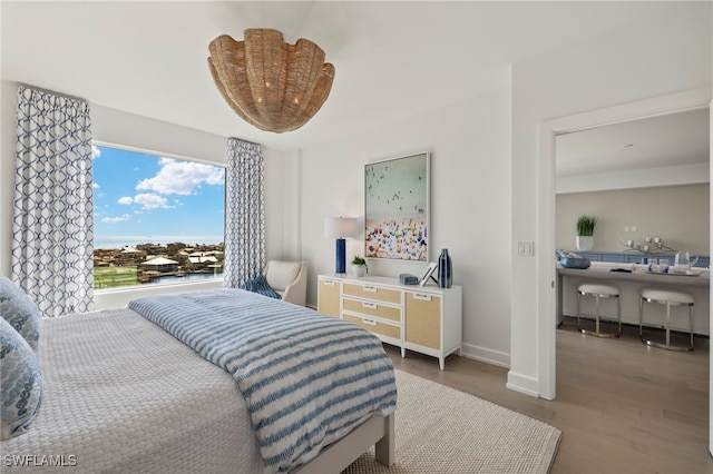 bedroom with baseboards and wood finished floors