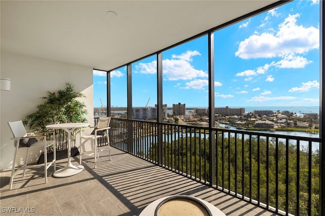 sunroom / solarium featuring a view of city and a water view