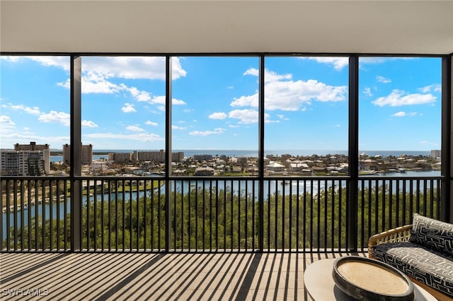 unfurnished sunroom featuring a view of city and a water view