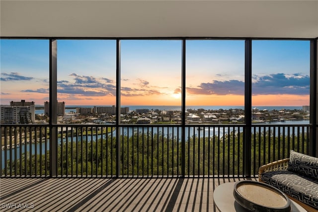 sunroom with a water view and a city view