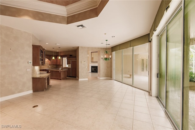 unfurnished living room with crown molding and light tile patterned floors