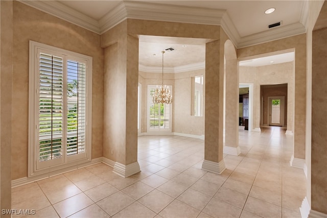 empty room with decorative columns, crown molding, and a chandelier