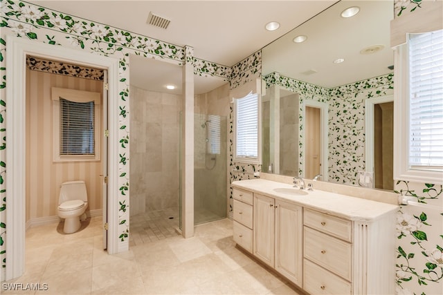 bathroom with vanity, toilet, and tiled shower