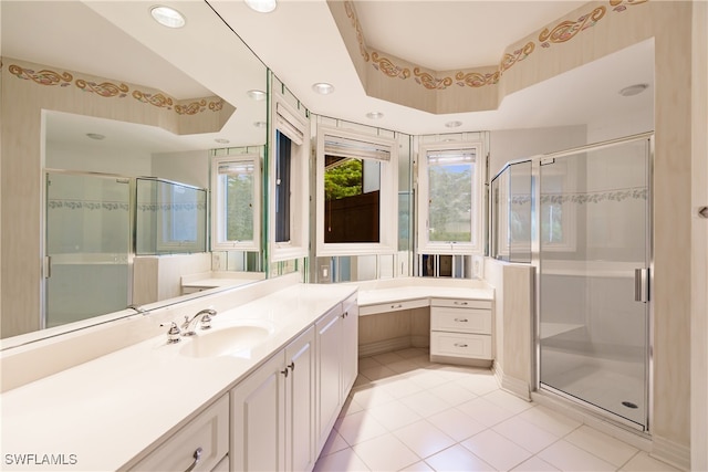 bathroom with tile patterned floors, an enclosed shower, a tray ceiling, and vanity