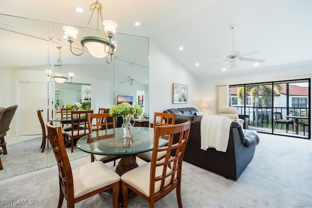 carpeted dining area with lofted ceiling and ceiling fan with notable chandelier