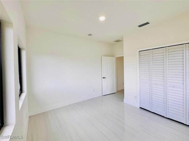 unfurnished bedroom with recessed lighting, a closet, visible vents, and baseboards