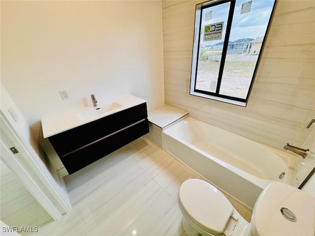 full bath featuring a washtub, vanity, and toilet