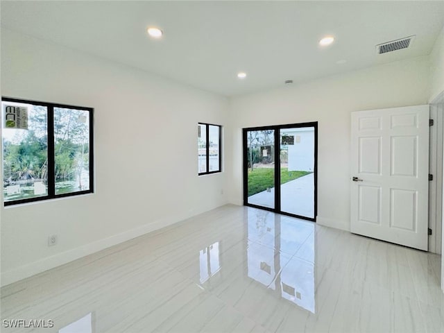 unfurnished room featuring baseboards, visible vents, and recessed lighting