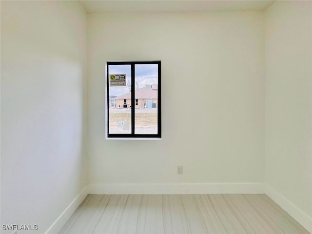 empty room with wood finished floors and baseboards