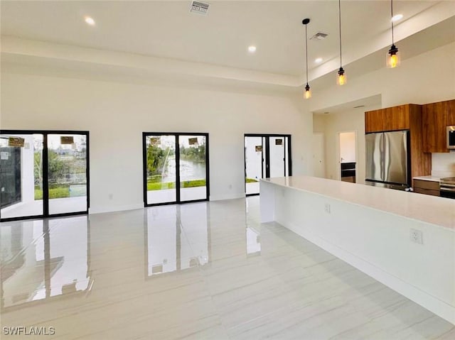 interior space with a healthy amount of sunlight, marble finish floor, a high ceiling, and visible vents