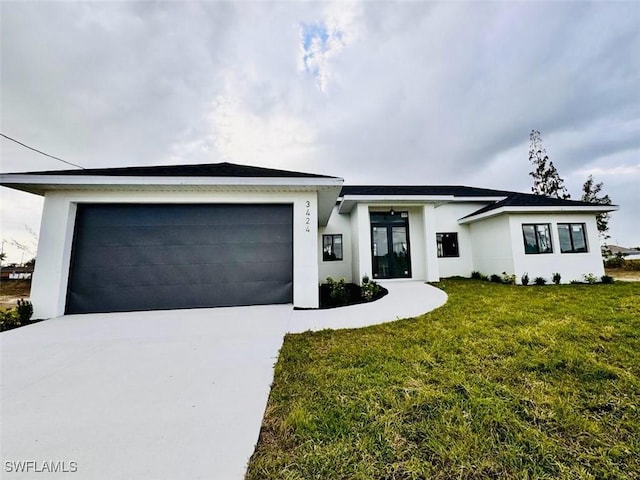 view of front of house with a garage, concrete driveway, a front lawn, and stucco siding