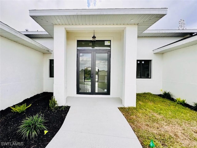 property entrance featuring stucco siding and french doors