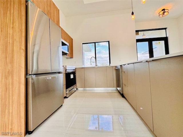 kitchen with a wainscoted wall, light tile patterned floors, stainless steel appliances, light countertops, and modern cabinets