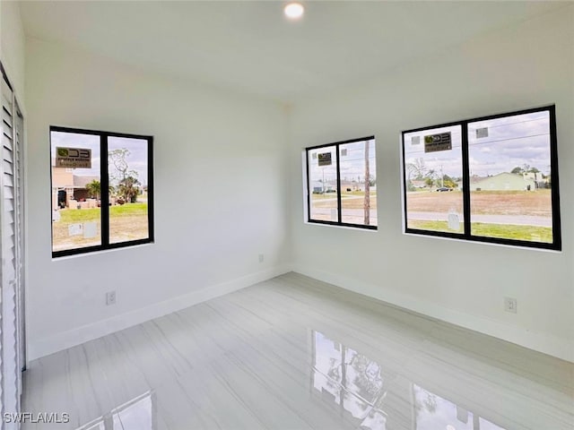 unfurnished room with recessed lighting and baseboards