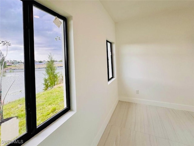 unfurnished room with plenty of natural light and baseboards