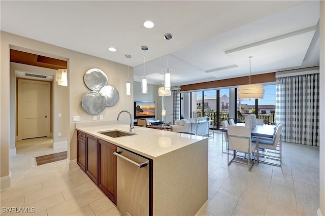 kitchen with light stone countertops, sink, stainless steel dishwasher, and decorative light fixtures