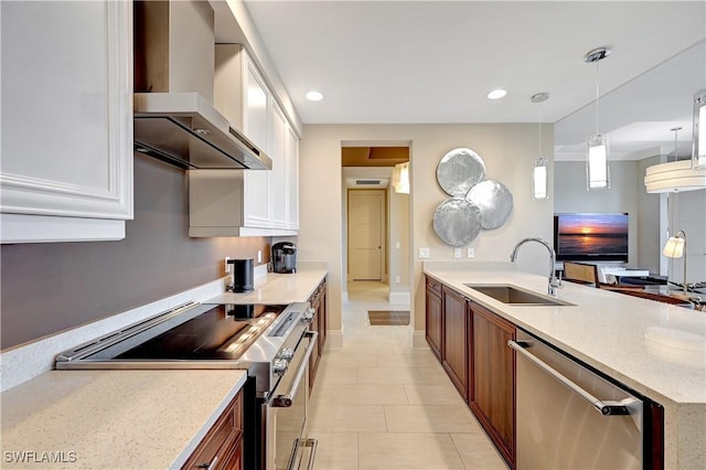 kitchen with pendant lighting, wall chimney range hood, stainless steel appliances, light stone countertops, and white cabinets