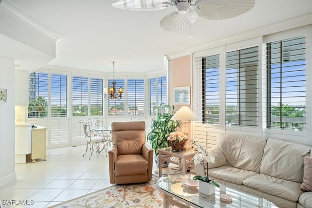 living room featuring ornamental molding, ceiling fan with notable chandelier, and light tile patterned floors