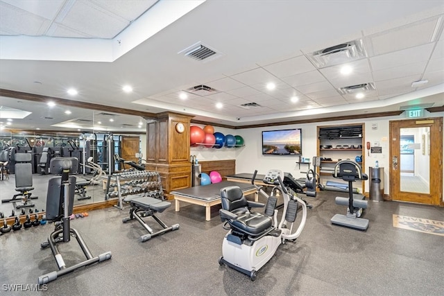 gym featuring a drop ceiling and a tray ceiling