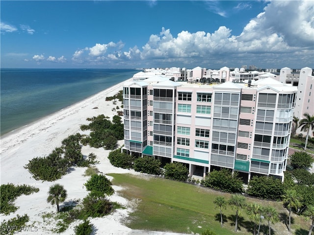 view of building exterior with a beach view and a water view