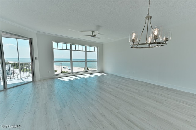 unfurnished room with ceiling fan with notable chandelier, a water view, a textured ceiling, ornamental molding, and light wood-type flooring