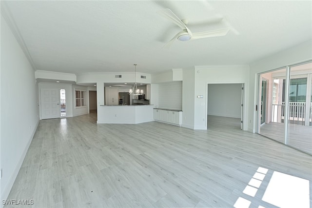 unfurnished living room featuring light wood-type flooring, ornamental molding, and ceiling fan with notable chandelier